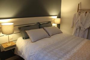 a bedroom with a bed with two pillows and two lamps at Appartement vue imprenable sur la Loire !!! in Saumur