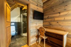 a bathroom with a toilet and a wooden wall at Panorama Alm Chalets by we rent JOKERCARD INCLUDED in Saalbach-Hinterglemm +49 photos