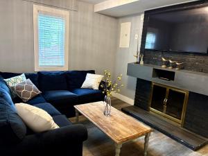 a living room with a blue couch and a fireplace at Brookswood Oasis - Guest suite,1 bedroom,1 den & 1 full bathroom in Langley