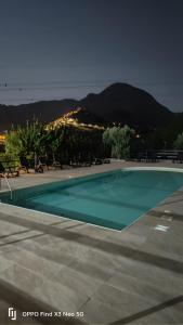 a swimming pool at night with mountains in the background at Villa Rosaria B&B in Morano Calabro