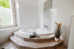 a white bathroom with a tub and a window at Altbau-Traum, Zentrumsnah, Küche, Whirlpool in Braunschweig +21 photos
