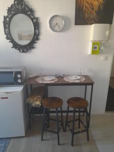 a table with two chairs and a clock on the wall at S C I TREFLe in Vernon +7 photos