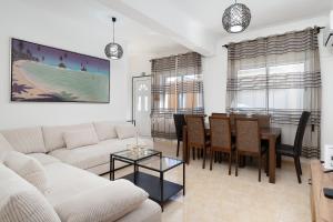 a living room with a couch and a dining room at Casa Linda in Olhão