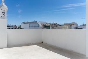a white wall with a clock on top of it at Casa Linda in Olhão