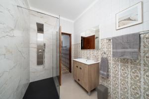 a bathroom with a shower and a sink and a mirror at Casa Linda in Olhão +118 photos