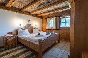 a bedroom with a large bed with a wooden ceiling at Panorama Alm Chalets by we rent JOKERCARD INCLUDED in Saalbach-Hinterglemm