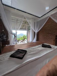 a bedroom with a large white bed with a window at Brisk Ella Retreat in Ella