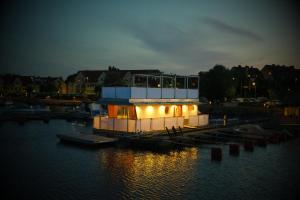 a small house on the water at night at Unique floating retreat Sleeps 4 in Sölvesborg +6 photos