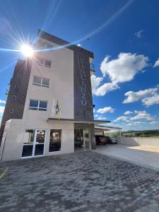 a building with the sun on top of it at Vincenzo Hotel in São Vicente de Minas
