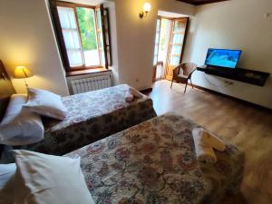 a hotel room with two beds and a television at Airtegal Casa do Puntal in Valdoviño