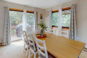 a dining room with a wooden table and some windows at House in the Woods in Albrightsville