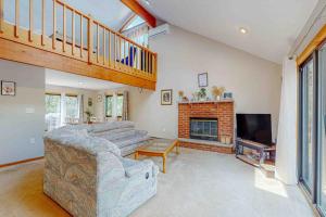 a living room with a couch and a fireplace at House in the Woods in Albrightsville