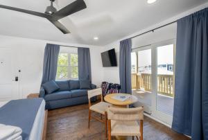 a bedroom with a bed and a couch and a table at The Silver Lake Hotel at Ocracoke in Ocracoke