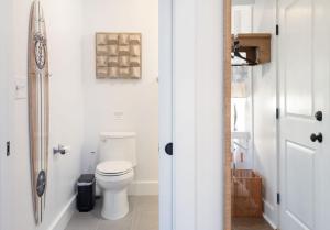 a white bathroom with a toilet and a mirror at The Silver Lake Hotel at Ocracoke in Ocracoke +31 photos