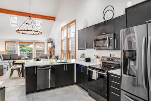 a kitchen with stainless steel appliances and a living room at House Juniper in Tannersville