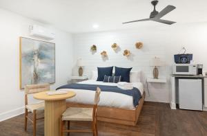 a bedroom with a bed and a table and a microwave at The Silver Lake Hotel at Ocracoke in Ocracoke