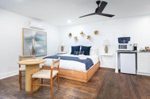 a bedroom with a bed and a table and a kitchen at The Silver Lake Hotel at Ocracoke in Ocracoke