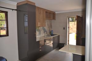 a kitchen with brown cabinets and a sink at Sea & Forest Self Catering Estate - Durban Kingsburgh in Kingsborough
