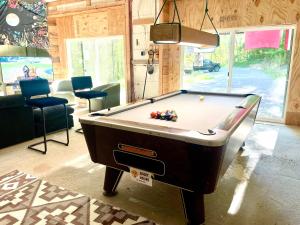 a pool table sitting in a room with ahibition at The Arete Hostel and Suites in Summersville