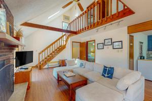 a living room with a white couch and a tv at The Burrow in Jim Thorpe