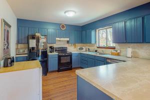 a large blue kitchen with blue cabinets and appliances at The Burrow in Jim Thorpe +39 photos