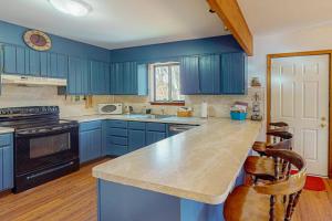 a kitchen with blue cabinets and a counter top at The Burrow in Jim Thorpe