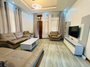a living room with a couch and a tv at Peaceful Home in Kigali