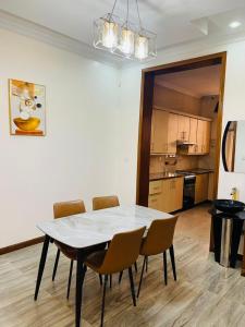 a dining room table with chairs and a kitchen at Peaceful Home in Kigali