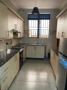 a large kitchen with white cabinets and a sink at Peaceful Home in Kigali +2 photos