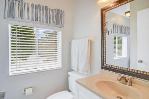 a bathroom with a sink and a mirror and a toilet at Sanibel Sandals & Flip Flops in Sanibel +56 photos