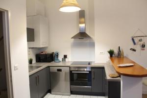 a kitchen with a sink and a stove top oven at Appartement vue imprenable sur la Loire !!! in Saumur