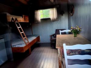 a room with a bunk bed and a table with a table sidx sidx sidx at Fossen Camping Fagernes in Døvre