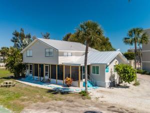 a house with a palm tree in front of it at Sanibel Sandals & Flip Flops in Sanibel