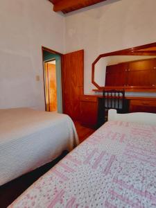 a bedroom with two beds and a dresser at Fy Lle -Mi lugar- Gaiman in Gaiman