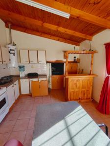 a large kitchen with wooden ceilings and a large room at Fy Lle -Mi lugar- Gaiman in Gaiman