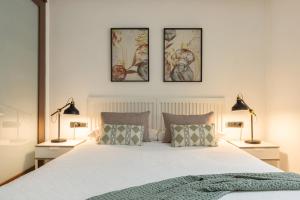 a bedroom with a bed with three pictures on the wall at Portu Casa Albero I Aston Rentals in Portugalete