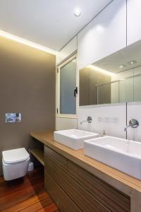 a bathroom with two sinks and a toilet and a mirror at Portu Casa Albero I Aston Rentals in Portugalete +18 photos