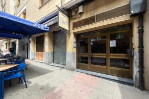 a restaurant with tables and a blue umbrella on a street at Portu Casa Albero I Aston Rentals in Portugalete