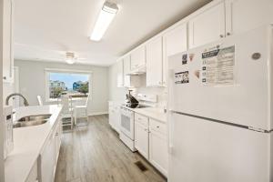 a white kitchen with a sink and a refrigerator at CAC-15B - Pollock in Buxton