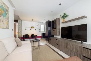 a living room with a white couch and a large television at Portu Casa Albero I Aston Rentals in Portugalete