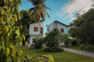 a white house with a palm tree in a yard at Nil Nadiya Holiday Resort in Matara