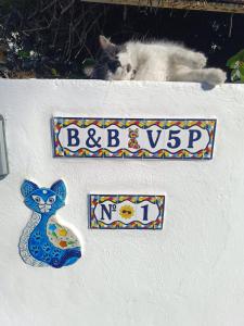 a cat laying on a wall with signs on it at Villa Cinque Pini in Casamicciola Terme