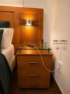 a nightstand with a lamp on it next to a bed at Casa da Marquês in Petrópolis