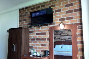 a room with a brick wall with a tv on a wall at Nil Nadiya Holiday Resort in Matara