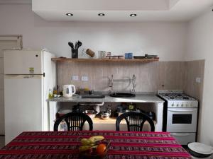 a kitchen with a stove and a table with chairs at Casa Bati in El Mollar
