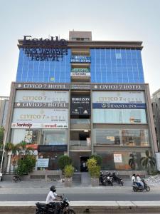 a group of people riding motorcycles in front of a building at Hotel Prime Divine in Ahmedabad