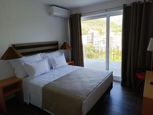 a hotel room with a bed and a large window at Casa do Patrão Serradalto in Manteigas
