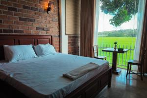 a bed in a bedroom with a brick wall at Nil Nadiya Holiday Resort in Matara