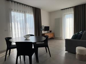 a living room with a table and chairs and a couch at Appartamenti Nataly in Nago-Torbole