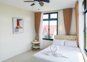 a bedroom with a white bed with a bow on it at Casa Gomes Amuntay in Dasmariñas